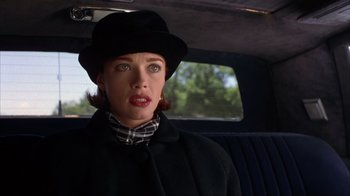 Movie still from “Dumb and Dumber” (1994), directed by Peter Farrelly – A woman in a black coat and a hat in a car; Close Up shot, Over the shoulder angle