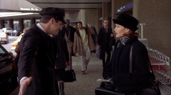 Movie still from “Dumb and Dumber” (1994), directed by Peter Farrelly – A man and a woman are talking to each other in an airport; Medium shot, Over the shoulder angle