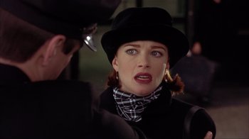 Movie still from “Dumb and Dumber” (1994), directed by Peter Farrelly – A woman wearing a black hat and a black and white checkered scarf; Close Up shot, Over the shoulder angle