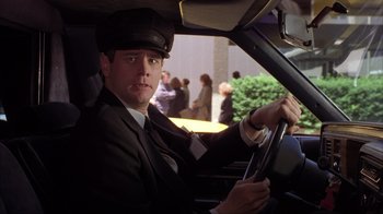 Movie still from “Dumb and Dumber” (1994), directed by Peter Farrelly – A man sitting in the driver's seat of a car; Close Up shot, Low angle