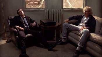 Movie still from “Dumb and Dumber” (1994), directed by Peter Farrelly – A group of men sitting on a couch next to each other; Wide shot, High angle