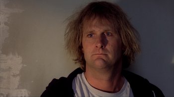 Movie still from “Dumb and Dumber” (1994), directed by Peter Farrelly – A person wearing a white t - shirt; Close Up shot, Low angle