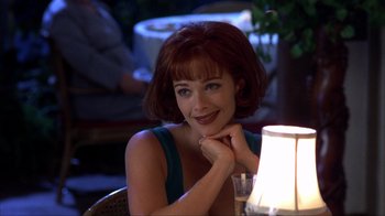 Movie still from “Dumb and Dumber” (1994), directed by Peter Farrelly – A woman sitting in front of a table with a lit candle; Close Up shot, Over the shoulder angle