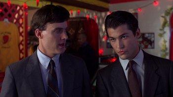 Movie still from “Dumb and Dumber” (1994), directed by Peter Farrelly – Two men in suits and ties standing next to each other; Close Up shot, Low angle