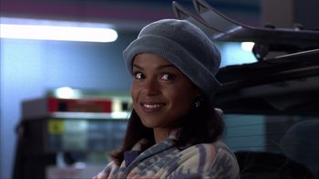 Movie still from “Dumb and Dumber” (1994), directed by Peter Farrelly – A woman wearing a gray hat and a colorful jacket; Close Up shot, Over the shoulder angle