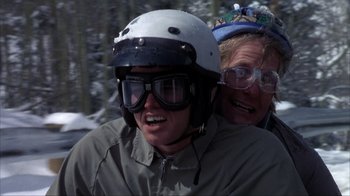 Movie still from “Dumb and Dumber” (1994), directed by Peter Farrelly – A man riding a motorcycle with a helmet on his head; Medium shot, Low angle