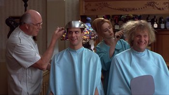 Movie still from “Dumb and Dumber” (1994), directed by Peter Farrelly – A man getting his head shaved by a woman; Medium shot, Over the shoulder angle