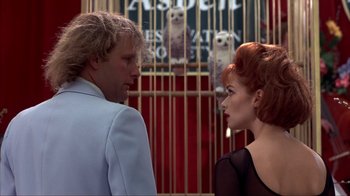 Movie still from “Dumb and Dumber” (1994), directed by Peter Farrelly – A man and a woman standing next to each other in front of a cage; Close Up shot, Over the shoulder angle