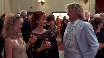 Movie still from “Dumb and Dumber” (1994), directed by Peter Farrelly – A woman and a man are talking to each other at an event; Medium shot, Low angle