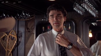 Movie still from “Dumb and Dumber” (1994), directed by Peter Farrelly – A man adjusting his neck tie while standing in a room; Close Up shot, Low angle