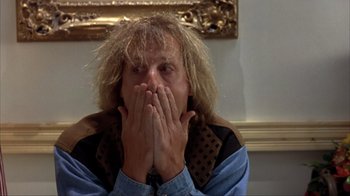 Movie still from “Dumb and Dumber” (1994), directed by Peter Farrelly – A man with his hands over his mouth; Close Up shot, Over the shoulder angle
