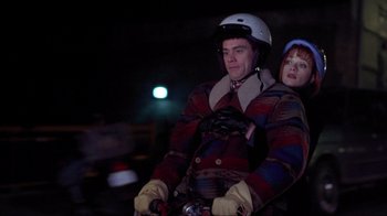 Movie still from “Dumb and Dumber” (1994), directed by Peter Farrelly – A man and a woman riding a bike at night; Medium shot, Low angle