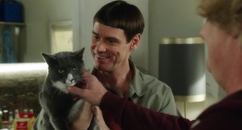 Movie still from “Dumb and Dumber To” (2014), directed by Peter Farrelly – A man is holding a cat and smiling; Close Up shot, Over the shoulder angle