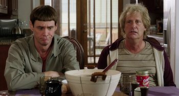Movie still from “Dumb and Dumber To” (2014), directed by Peter Farrelly – Two people sitting at a table with a bowl of food; Medium shot, Over the shoulder angle