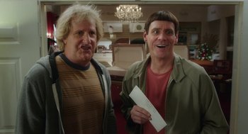 Movie still from “Dumb and Dumber To” (2014), directed by Peter Farrelly – Two men standing next to each other and one of them is holding an envelope; Medium shot, Over the shoulder angle