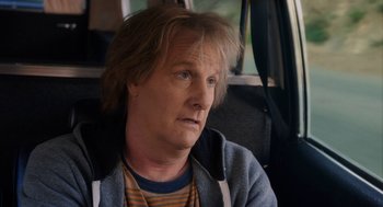 Movie still from “Dumb and Dumber To” (2014), directed by Peter Farrelly – A man sitting in the back seat of a car; Close Up shot, Over the shoulder angle