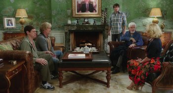 Movie still from “Dumb and Dumber To” (2014), directed by Peter Farrelly – A group of people sitting around a fire place; Wide shot, Over the shoulder angle