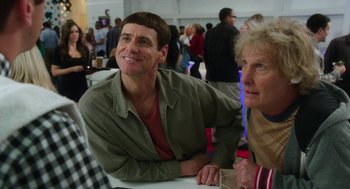 Movie still from “Dumb and Dumber To” (2014), directed by Peter Farrelly – A man and a woman sitting next to each other at an event; Close Up shot, Over the shoulder angle