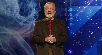 Movie still from “Dumb and Dumber To” (2014), directed by Peter Farrelly – An older man wearing a suit and a bow tie; Medium shot, Over the shoulder angle