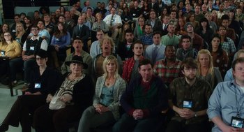 Movie still from “Dumb and Dumber To” (2014), directed by Peter Farrelly – A large group of people sitting in a room; Wide shot, High angle