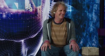 Movie still from “Dumb and Dumber To” (2014), directed by Peter Farrelly – A man sitting in front of an image of a computer screen; Medium shot, Over the shoulder angle