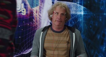 Movie still from “Dumb and Dumber To” (2014), directed by Peter Farrelly – A man with blonde curly hair and a striped shirt; Close Up shot, Over the shoulder angle