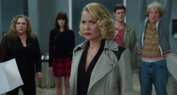 Movie still from “Dumb and Dumber To” (2014), directed by Peter Farrelly – A woman wearing a leather jacket standing in front of two other people; Medium shot, Over the shoulder angle