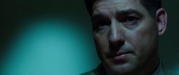 Movie still from “Dying of the Light” (2014), directed by Paul Schrader – A man's face in a dark room; Close Up shot, Over the shoulder angle
