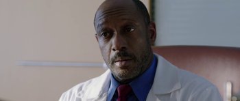 Movie still from “Dying of the Light” (2014), directed by Paul Schrader – A person wearing a lab coat; Close Up shot, Low angle