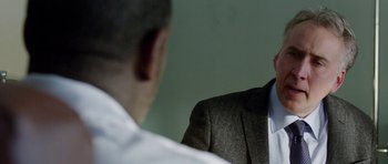 Movie still from “Dying of the Light” (2014), directed by Paul Schrader – A man in a suit and tie talking to another man in a white shirt; Close Up shot, Over the shoulder angle