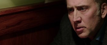 Movie still from “Dying of the Light” (2014), directed by Paul Schrader – A person sitting down with his eyes wide open; Close Up shot, Over the shoulder angle