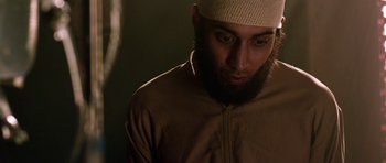 Movie still from “Dying of the Light” (2014), directed by Paul Schrader – A person wearing a hat; Close Up shot, Over the shoulder angle