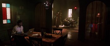 Movie still from “Dying of the Light” (2014), directed by Paul Schrader – A living room filled with furniture next to a fire place; Wide shot, High angle