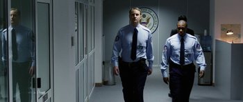 Movie still from “Dying of the Light” (2014), directed by Paul Schrader – A man in uniform walking down a hall way; Medium shot, Low angle