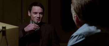 Movie still from “Dying of the Light” (2014), directed by Paul Schrader – A man in a suit is holding a cigarette in front of a mirror; Close Up shot, Over the shoulder angle