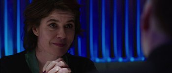 Movie still from “Dying of the Light” (2014), directed by Paul Schrader – A person sitting in front of a blue background; Close Up shot, Over the shoulder angle