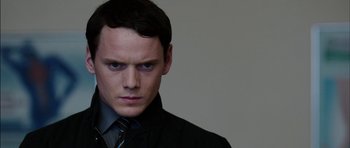 Movie still from “Dying of the Light” (2014), directed by Paul Schrader – A person wearing a suit and tie; Close Up shot, Over the shoulder angle