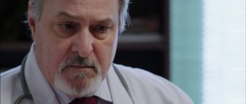 Movie still from “Dying of the Light” (2014), directed by Paul Schrader – An older man wearing a white shirt and a red tie; Close Up shot, Low angle