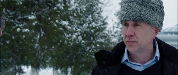 Movie still from “Dying of the Light” (2014), directed by Paul Schrader – A man wearing a coat and a hat in the snow; Close Up shot, Over the shoulder angle