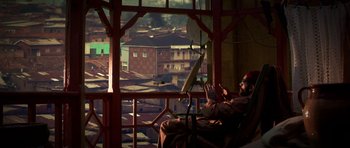 Movie still from “Dying of the Light” (2014), directed by Paul Schrader – A man sitting in a chair in front of a large window; Wide shot, High angle
