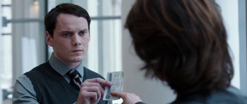 Movie still from “Dying of the Light” (2014), directed by Paul Schrader – A man in a business suit is holding a passport; Close Up shot, Over the shoulder angle