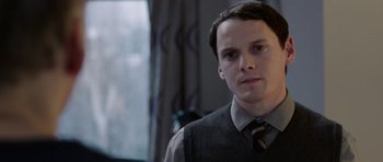 Movie still from “Dying of the Light” (2014), directed by Paul Schrader – A man in a tie and vest looking at the camera; Close Up shot, Over the shoulder angle