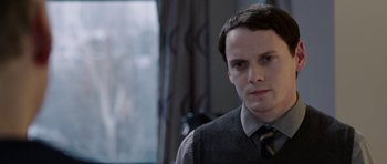 Movie still from “Dying of the Light” (2014), directed by Paul Schrader – A man in a tie and vest looking at the camera; Close Up shot, Over the shoulder angle