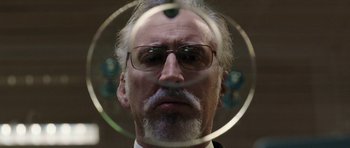 Movie still from “Dying of the Light” (2014), directed by Paul Schrader – An older man with a beard wearing glasses and a suit; Close Up shot, Low angle