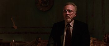 Movie still from “Dying of the Light” (2014), directed by Paul Schrader – An older man in a suit and tie; Medium shot, Low angle