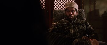 Movie still from “Dying of the Light” (2014), directed by Paul Schrader – A man sitting in a chair with a blanket on his lap; Medium shot, Low angle