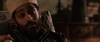 Movie still from “Dying of the Light” (2014), directed by Paul Schrader – A man with a beard wearing a hat; Close Up shot, High angle