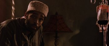 Movie still from “Dying of the Light” (2014), directed by Paul Schrader – A man with a beard wearing a hat and looking at the camera; Close Up shot, Low angle