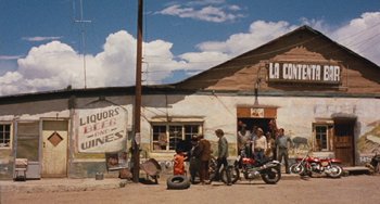 Movie still from “Easy Rider” (1969), directed by Dennis Hopper – A group of people standing outside of a building; Extreme Wide shot, Low angle