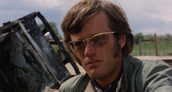 Movie still from “Easy Rider” (1969), directed by Dennis Hopper – A person wearing sunglasses; Close Up shot, Low angle